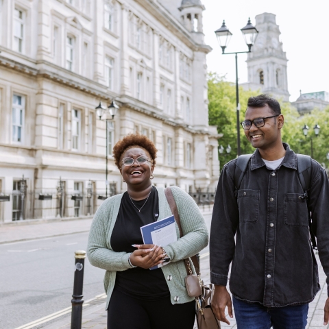 Two students walking and smiling