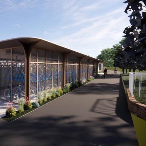 Person on bike with the proposed cycle hub behind