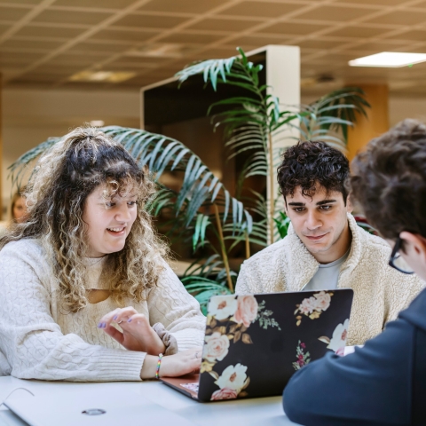 Three students conversing in a study space