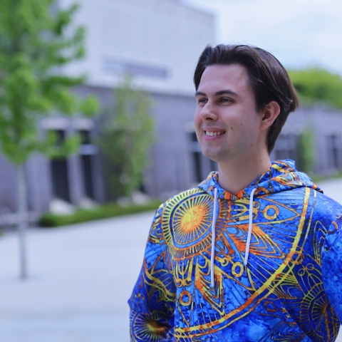 Student wearing colorful hoodie and smiling.