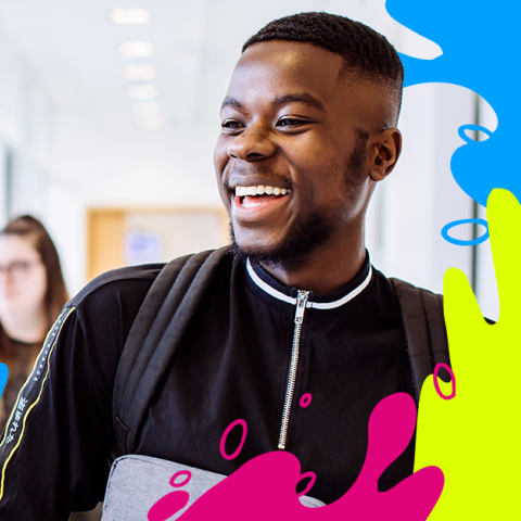 Two students smiling in a university building with colourful splashes around them