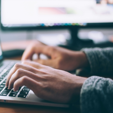 hands typing on a computer