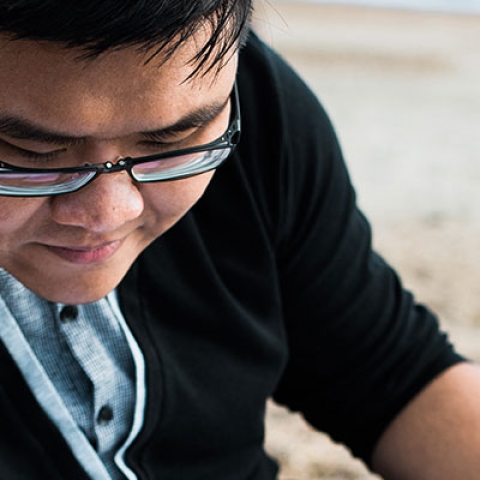 A student studying at the beach.