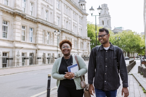 Two students walking and smiling