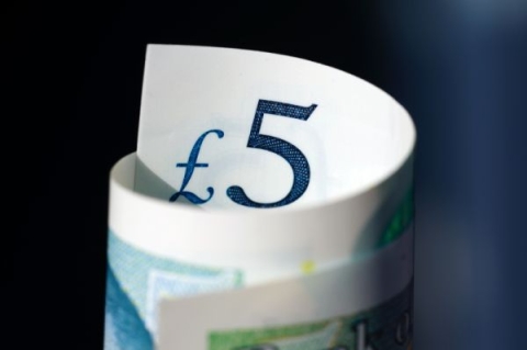 A rolled up five pound note 