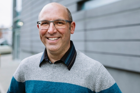 Professor George Burrows smiling in front a blurred out background