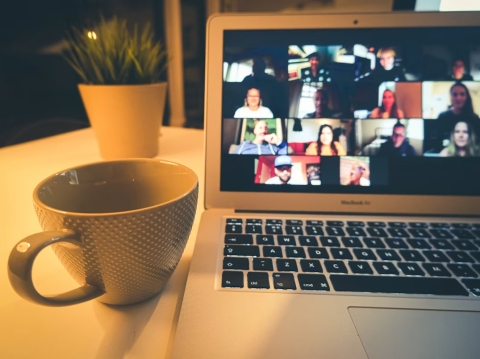 Photo of a cup of tea and a laptop with a zoom meeting taking place