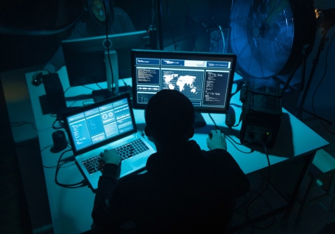 Computer hacker working at laptop
