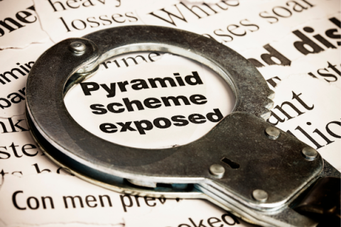 Handcuff on top of news article reading Pyramid scheme exposed