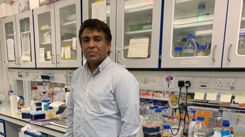 Photo of Binuraj Menon standing in a lab