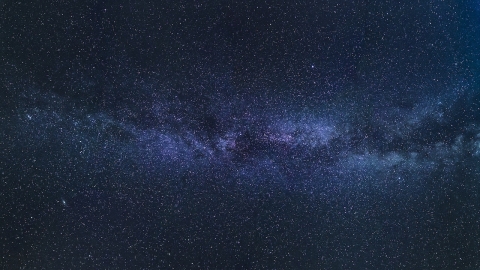 An image of a galaxy - a dark blue sky dotted with stars and a white cloudy patch across the middle