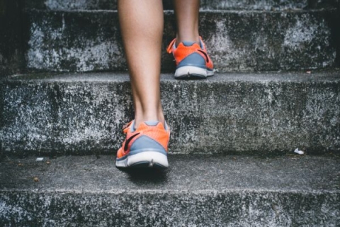 Close up of running shoes as a person climbs some concrete stairs