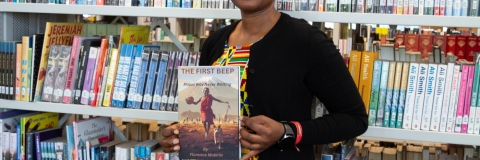 Alumnus and published author Florence Mukiria holding a copy of her debut novel