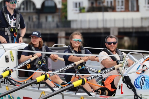 Three rowers rowing along The Thames river
