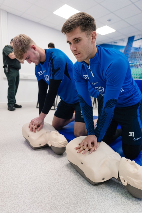 Two men performing CPR on mannekins.