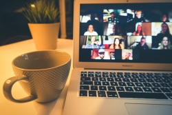 Photo of a cup of tea and a laptop with a zoom meeting taking place