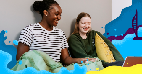 Two students sat on a bed in halls 