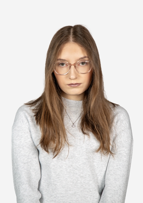 A person with long brown hair, wearing glasses and a light grey sweatshirt, shown against a plain white background.