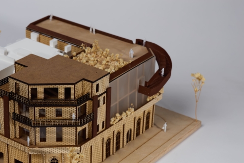 A multi‑storey architectural model with a curved roof element and fine detailing.