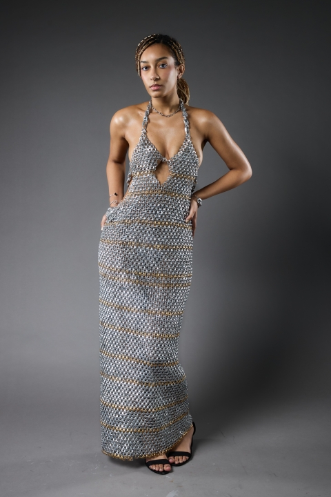 Model wearing a glittery/silver/grey dress whilst posing infront of a grey background