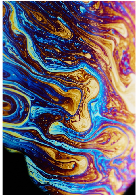 A close‑up of swirling blue, purple, yellow, and brown patterns creating a marbled, fluid abstract surface.